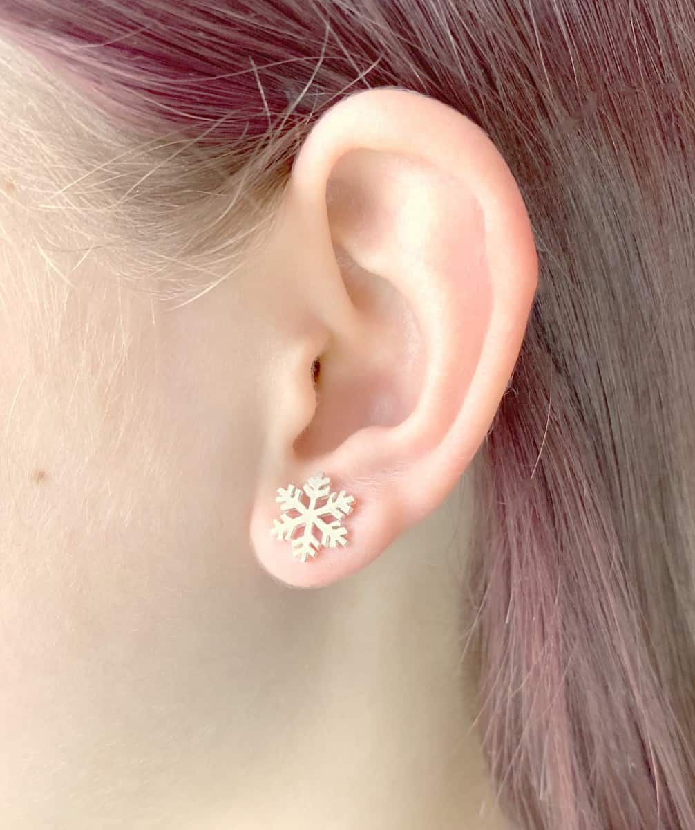 Medium size snowflake studs on ear